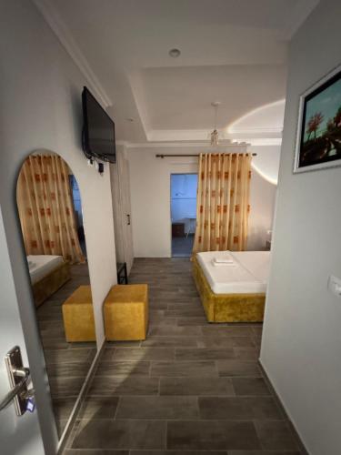 a room with a bed and a television and a bathroom at Vila Silvi Bala in Pilur