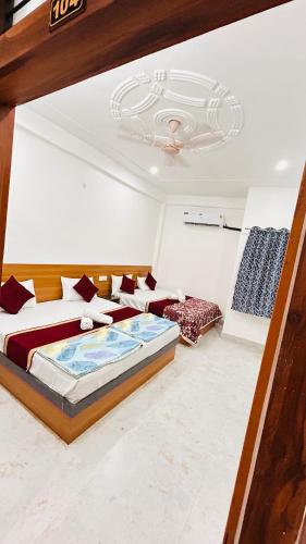 a bedroom with two beds and a ceiling at Shreevanya Inn in Ayodhya