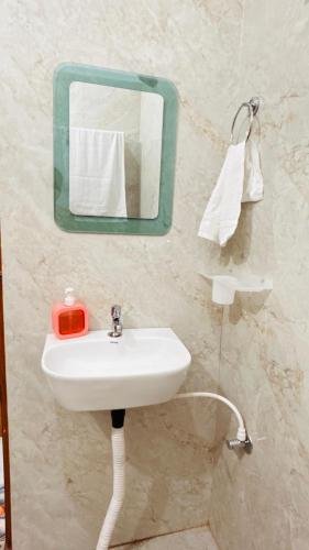a bathroom with a sink and a mirror at Shreevanya Inn in Ayodhya