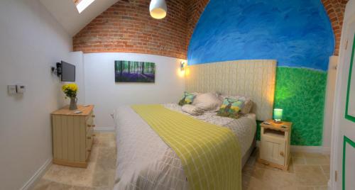 a bedroom with a bed and a brick wall at The Orangery in Thurning