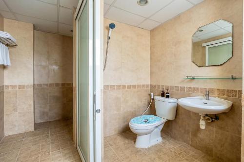 a bathroom with a toilet and a sink and a mirror at P ratunam Residence Hotel in Bangkok