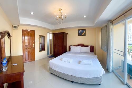 a bedroom with a large bed and a chandelier at P ratunam Residence Hotel in Bangkok