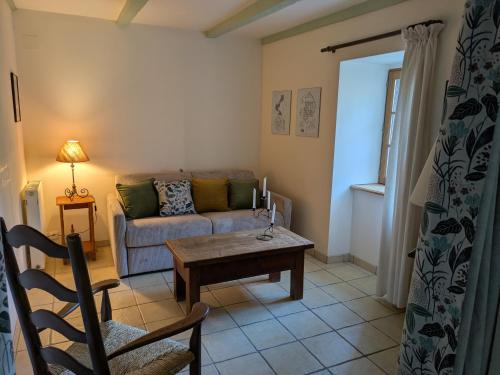 a living room with a couch and a table at Gite Les Bannes in Saint-Sauves- dʼAuvergne
