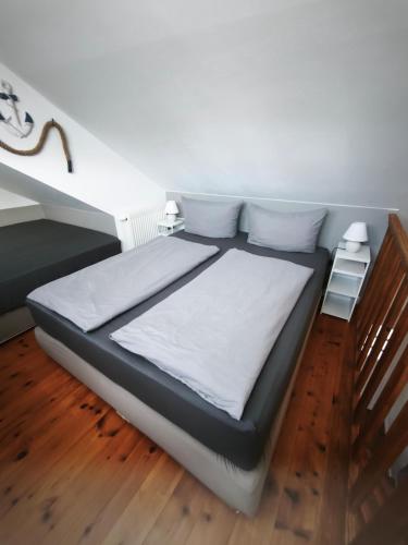 a bed with white sheets and pillows in a room at Juliusruh Strandparadies 12 in Juliusruh