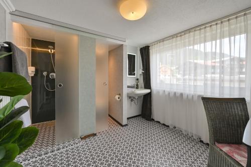 a bathroom with a sink and a shower and a toilet at Vintage Hotel Charivari- Sommer Hörnerbahnen kostenlos mit Restaurant in Bolsterlang