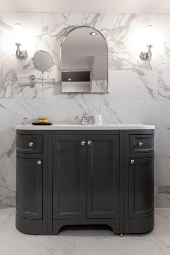 a bathroom with a black vanity and a mirror at The Kings Arms Hotel in Berwick-Upon-Tweed