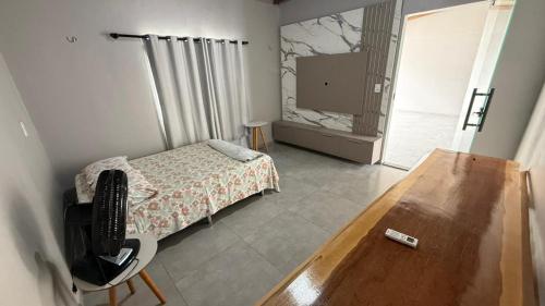 a bedroom with a bed and a desk and a television at Casa Paraíso de Alter in Santarém