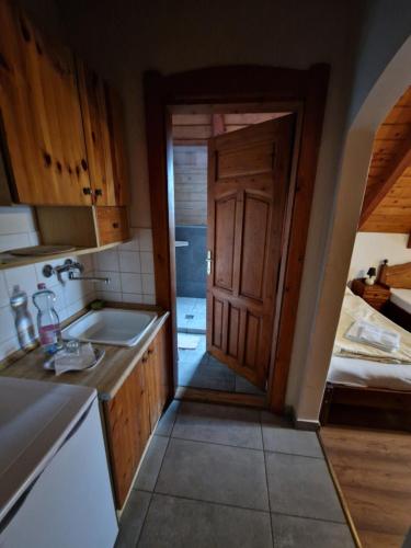 a kitchen with a door leading to a bathroom at Morvai Panzió in Mogyoród