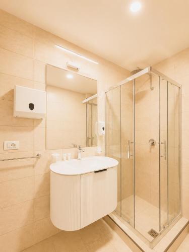 a bathroom with a sink and a shower at Kein Hotel in Durrës