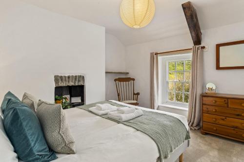 a bedroom with a bed with two towels on it at Manteg - quaint holiday cottage by the sea with direct beach access in Aber-Arth