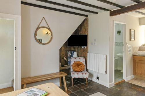 a living room with a mirror and a chair at Manteg - quaint holiday cottage by the sea with direct beach access in Aber-Arth