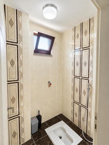 a bathroom with a urinal on a tiled wall at Rize Akarsu Apart in Rize