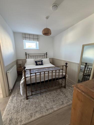 a bedroom with a bed and a mirror at One bedroom flat in Pevensey Bay in Pevensey
