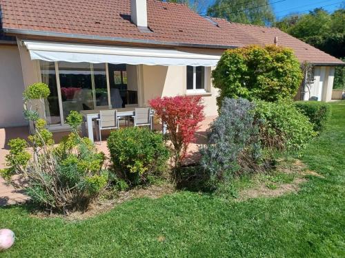 a house with a porch with plants in the yard at Maison confortable à Verdun avec jardin in Verdun-sur-Meuse