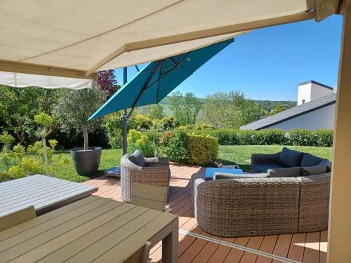 a patio with an umbrella and chairs and a table at Maison confortable à Verdun avec jardin in Verdun-sur-Meuse