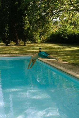 a man is diving into a swimming pool at La Suite de la Bastide in Val-de-Dagne