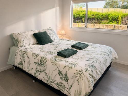 a bed with two green pillows on it in a bedroom at 19 Pimpama Home in Pimpama