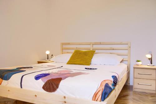 a bedroom with a large bed with a yellow pillow at Dana Apartments - Seafront Pašman in Pašman