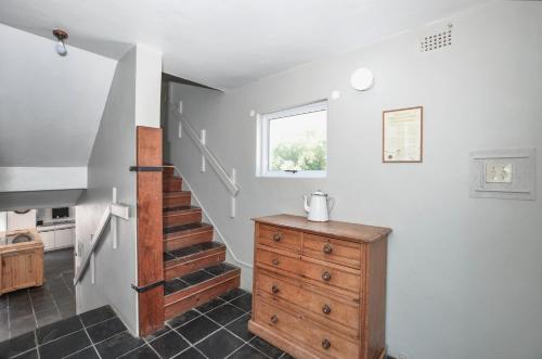 a room with a staircase and a wooden dresser at Voetjieshang in Yzerfontein