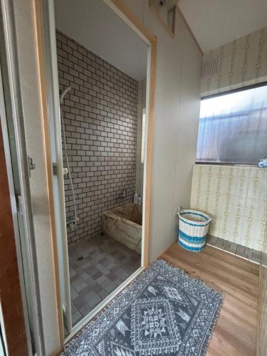 a bathroom with a shower and a glass door at 和の宿 禅 in Nachikatsuura