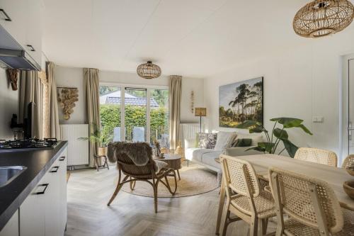 a kitchen and living room with a bed and a couch at Knusse Tiny house op de Veluwe in Epe