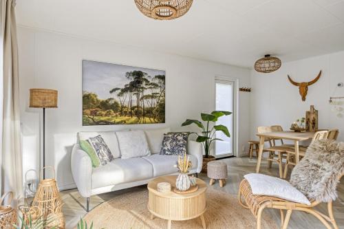 a living room with a couch and a table at Knusse Tiny house op de Veluwe in Epe