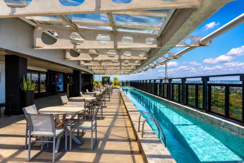 a row of tables and chairs next to a swimming pool at Intercity Salvador in Salvador