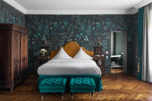 a bedroom with a large bed with green walls at Schloßhotel Althörnitz in Hörnitz