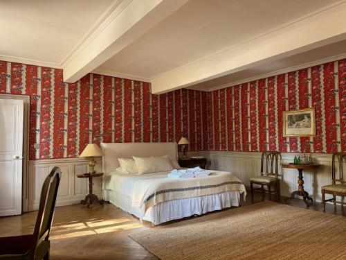 a bedroom with a bed and red wallpaper at La Suite de la Bastide in Val-de-Dagne