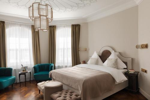 a bedroom with a bed and a blue chair at Schloßhotel Althörnitz in Hörnitz