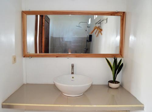 a bathroom with a white sink and a mirror at Rinjani inn Lombok in Tetebatu