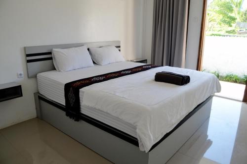 a bedroom with a bed with a black bag on it at Rinjani inn Lombok in Tetebatu