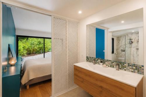 a bathroom with a bed and a sink and a mirror at Villa avec piscine chauffée, proche Saint-Tropez et plages in Gassin