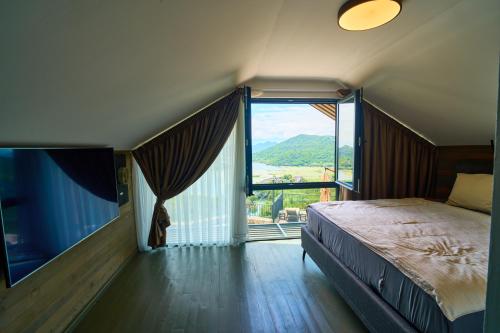 a bedroom with a bed and a large window at Skyline Skadar Lake in Karuč