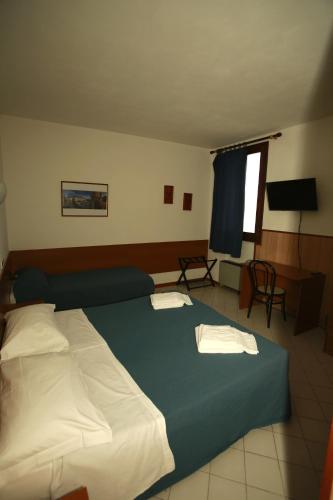a bedroom with a large bed with two towels on it at Affittacamere San Cristoforo Faenza in Faenza