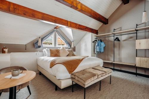 a bedroom with a large bed and a table at ISKÖ CHALETS-HÖTEL, Col d'Aubisque in Gourette