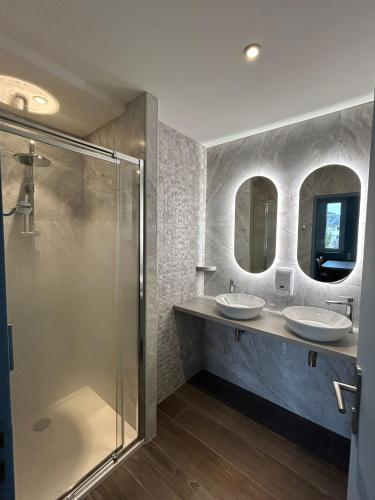 a bathroom with two sinks and two mirrors at Hostellerie Bon Pasteur in Angers