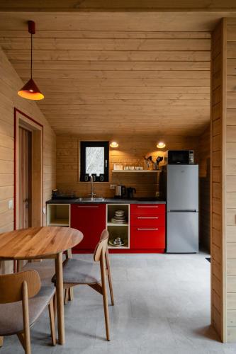a kitchen with a table and a refrigerator at УЛІС Віняви in Derevach
