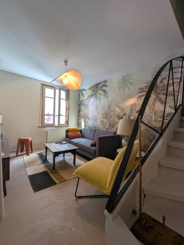a living room with a couch and a staircase at Les Chapeliers in Foix