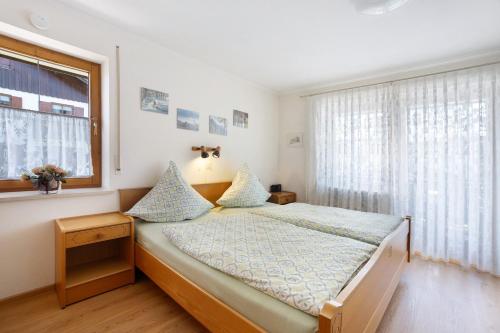 a bedroom with a bed and a window at Haus Grüntensee in Wertach