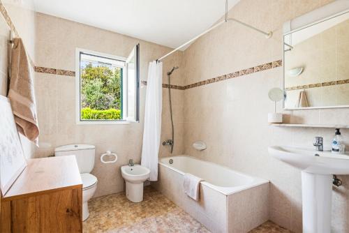 a bathroom with a sink and a toilet and a bath tub at Villa Ca Mestre Rafel by Escape Home in Santo Tomás