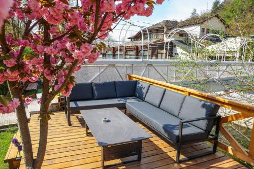 a blue couch and a table on a deck with a tree at Комплекс РАЙ in Ognyanovo