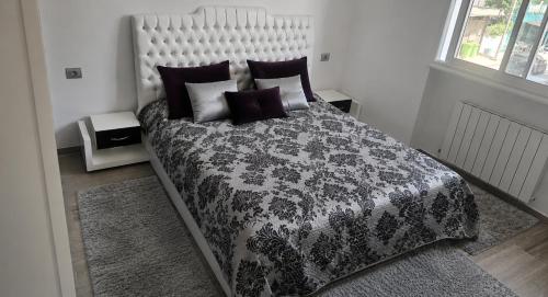 a bedroom with a black and white bed with pillows at Residence fedi in Monastir