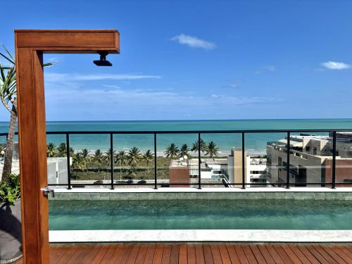 a balcony with a view of the ocean and a swimming pool at UMI Flats - Intermares by Refúgio Hospedagens in Cabedelo