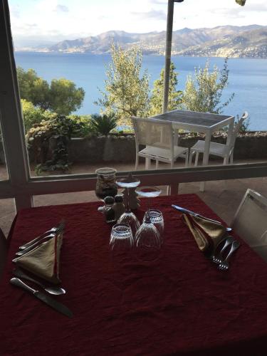 a table with glasses and utensils on it with a view of the ocean at Stella Maris Resort in Camogli