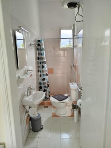 a bathroom with a white toilet and a sink at Mirkashouse in Limenas