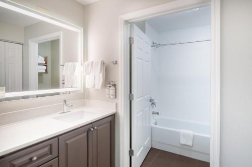 a white bathroom with a sink and a shower at Staybridge Suites Augusta by IHG in Augusta