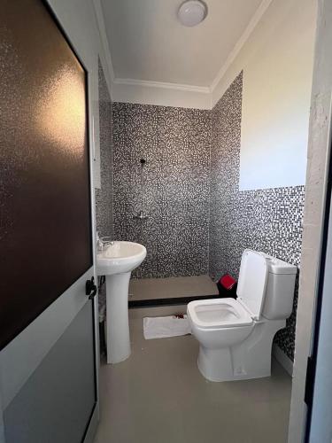 a bathroom with a toilet and a sink at Residencial Biva in Namibe