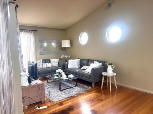 a living room with a couch and a table at Unit 4 The village light house in Metung
