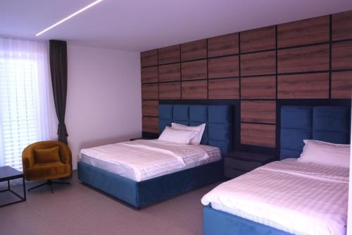 a bedroom with two beds and a chair at Rhein Suites in Eiken
